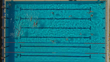 Aerial top view photo of people swimming and practising in outdoor pool