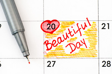 Reminder Beautiful Day in calendar with pen.