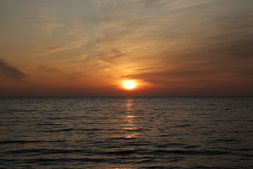 Beautiful bright sunset over the sea with reflection in the water.