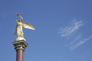 Statue or Sculpture Good angel of the world on the blue sky in Lazarevsky Sochi. Gilded figure with outstretched wings in the hands of a dove. A symbol of friendship and unity of different nations.