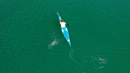 Aerial drone photo of man operating sport canoe in tropical exotic green lake