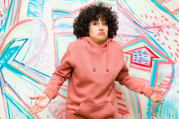 young pretty afro woman feeling clueless and confused, having no idea, absolutely puzzled with a...