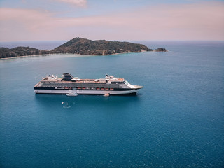 Bird eye view of the amazing white cruise ship sailing by the islands, blue ocean, horizon;...