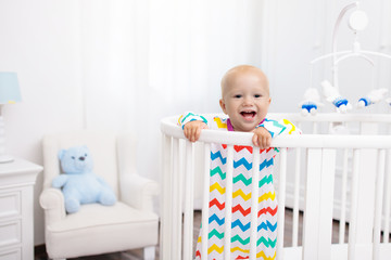 Little boy standing in bed