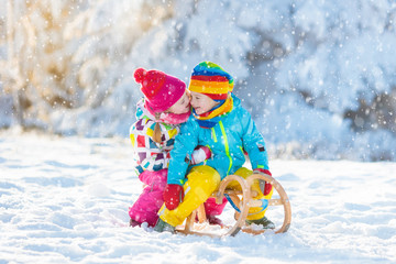 Kids play in snow. Winter sleigh ride for children