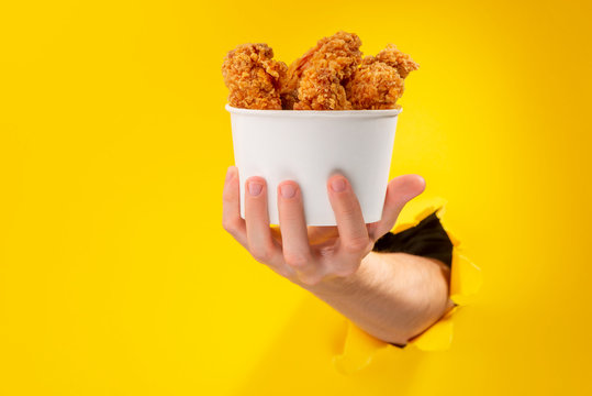 Hand giving chicken nuggets