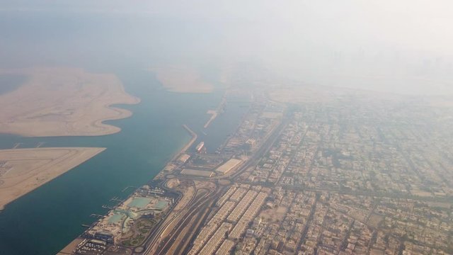 A aerial view of a city fully packed with residential area, business building and major ports.