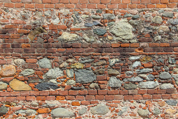 Wall made of natural rocks, bricks and scrap bricks 