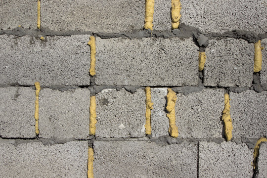 Wall made of granolith blocks with cement and mounting foam between blocks