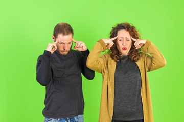 Young beautiful couple on isolated green background with hand on chin thinking about question, pensive expression. Smiling with thoughtful face. Doubt concept.