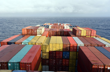 Large container ship, fully loaded with colorful containers sailing through the Pacific Ocean on a...