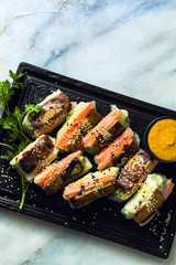 healthy vegan spring rice paper rolls with fried tofu cheese and fresh vegetables and almond sauce