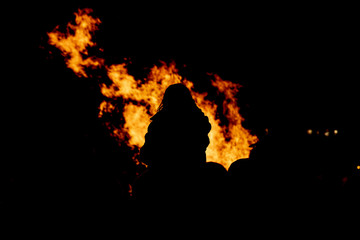 People watching fire burning at night