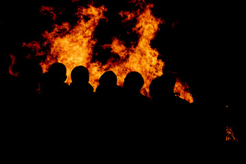 People watching fire burning at night