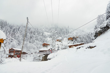 Wooden chalets under blizzard.