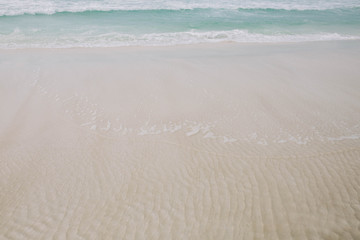 Beach with light blue water and white sand