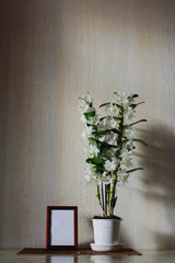 Flowers of White Nobile Dendrobium and frame on the table in the room