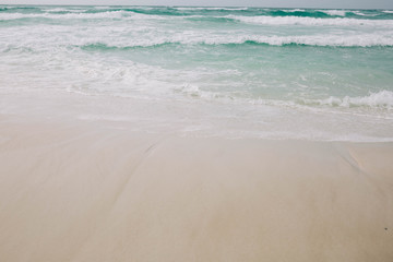 Fototapeta na wymiar Beach with light blue water and white sand