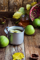 Rural mug with apple hot drink and fresh green apples