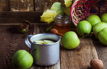 Rural mug with apple hot drink and fresh green apples