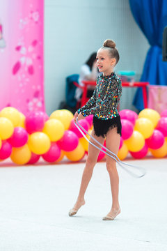 Beautiful little gymnast girl on the carpet on the competition