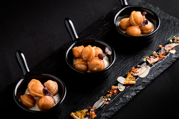 Mini dumplings on a beautiful dish on a dark background. Food concept for catering. Low key, copy space.