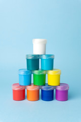 Colored paints on a clear blue background. Bright color paints for drawing