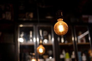 Two vintage incandescent lamps in a dark space on the background of an antique cabinet