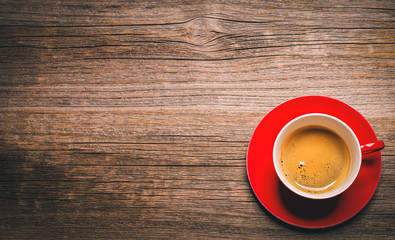 Cup of aromatic black coffee on a wooden background.