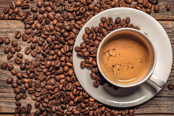 Cup of aromatic black coffee on a wooden background.