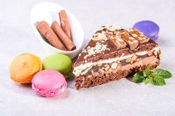 chocolate cake with macarons on a gray background