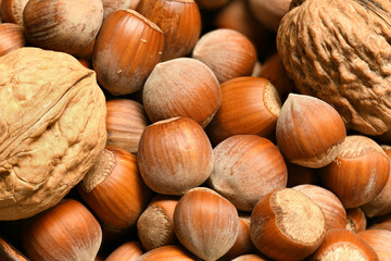 macro photo of nuts and walnuts - autumn harvest and healthy food concept. Yellow leaves. Still life on wooden background.