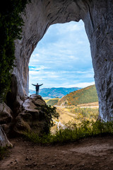 Oñati, Gipuzkoa / Spain »; October 27, 2019: A young man in La Cuevas de Ojo de Aitzulo with arms raised