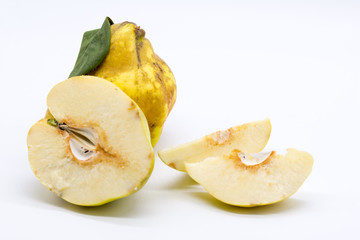 whole quince and slices of quince on white background