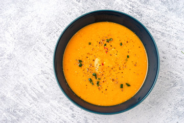 Top view of winter spicy lentil cream soup in white plate