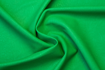 green artificial leather with waves and folds on PVC base