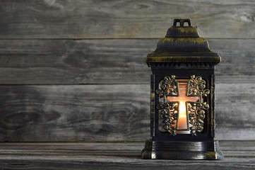 All Saints' Day votive candle on wooden background with copy space.