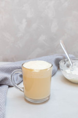 Cup of green tea topped with cream cheese foam on grey background. Homemade cheese tea