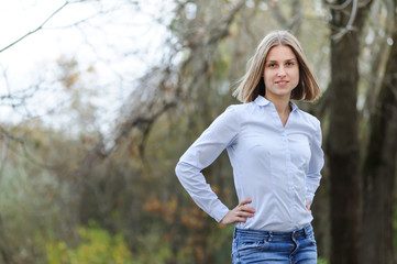 Casually dressed smiling business woman on a nature background