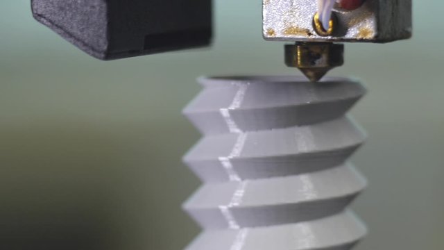 3D printer printing a gray screw