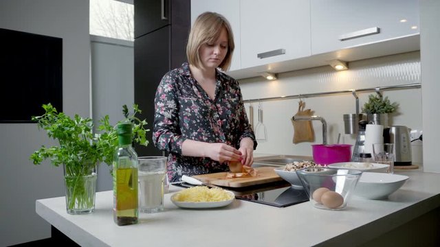 Young woman peeling and cutting onion