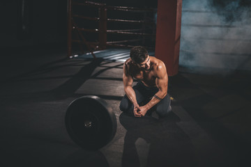 Professional bodybuilding man posing in front of the camera showing his big muscle in a cross fitness class