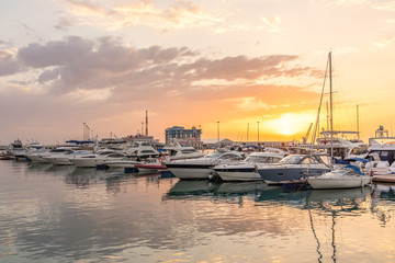 Yellow sunset in the sea harbor with moored yachts.