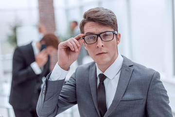 responsible business man looking through his glasses.