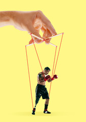 Man like a puppet in somebodies hands on yellow background. Concept of unfair manipulation,...
