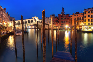 Famous Rialto Bridge or Ponte di Rialto over the Grand Canal in Venice during evening blue hour, Italy.