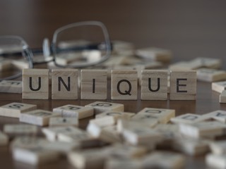 The concept of Unique represented by wooden letter tiles