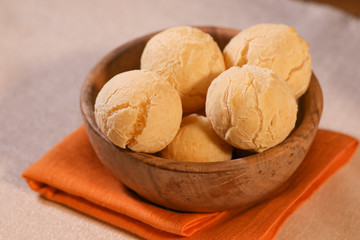 Pao de Queijo on wooden Bowl. Traditional cheese bread (pão de queijo) bowl on a table