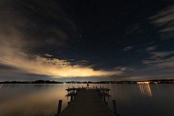 Fototapeta na wymiar Mann in der Nacht am See
