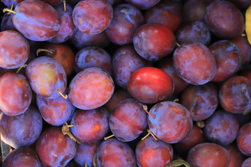 Background of ripe plums on the market